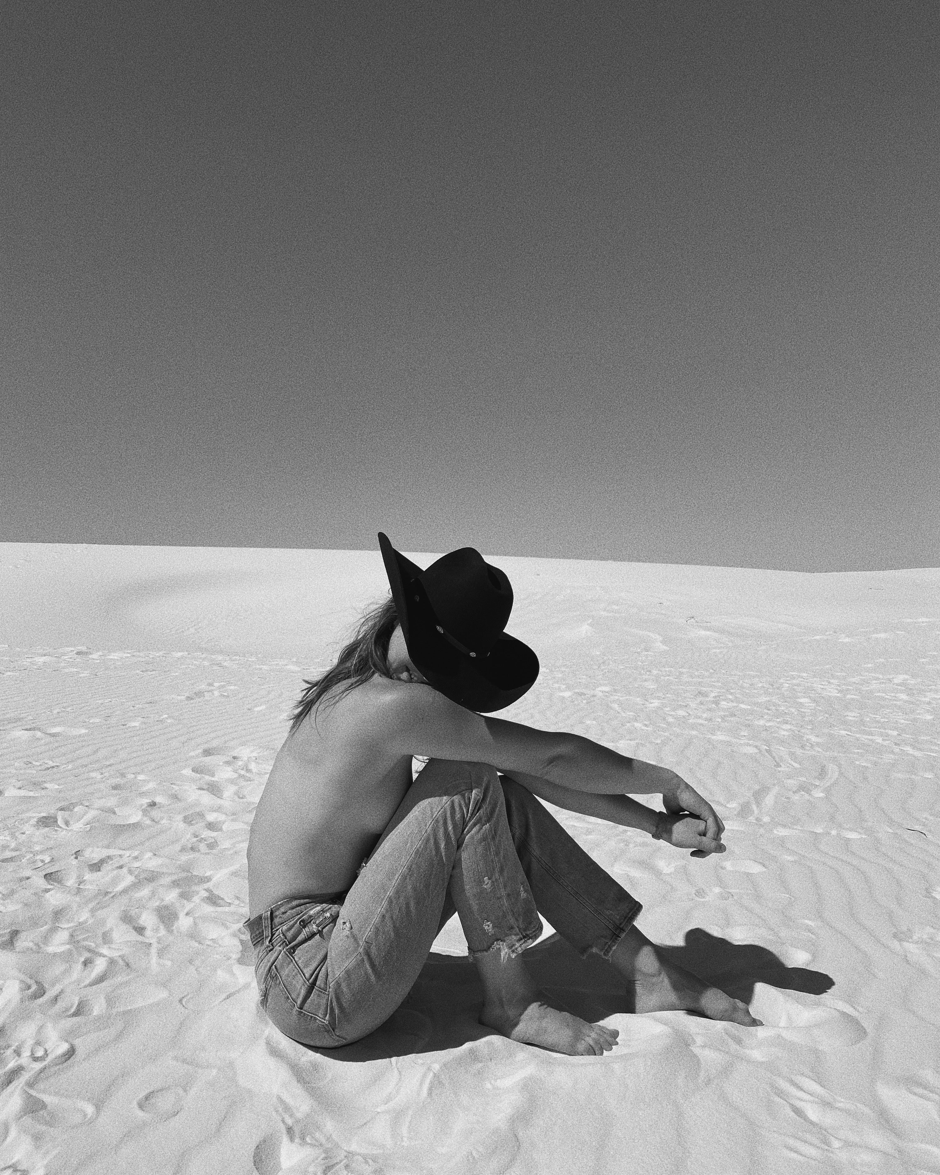 Woman holding a wide-brimmed hat in front of her face